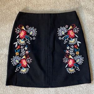 Black denim skirt with embroidered flower pattern